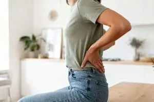 person holding lower back in pain